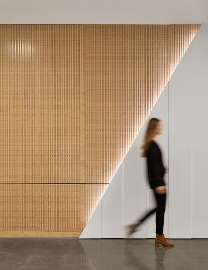 A woman walking past an ambient-lit wall